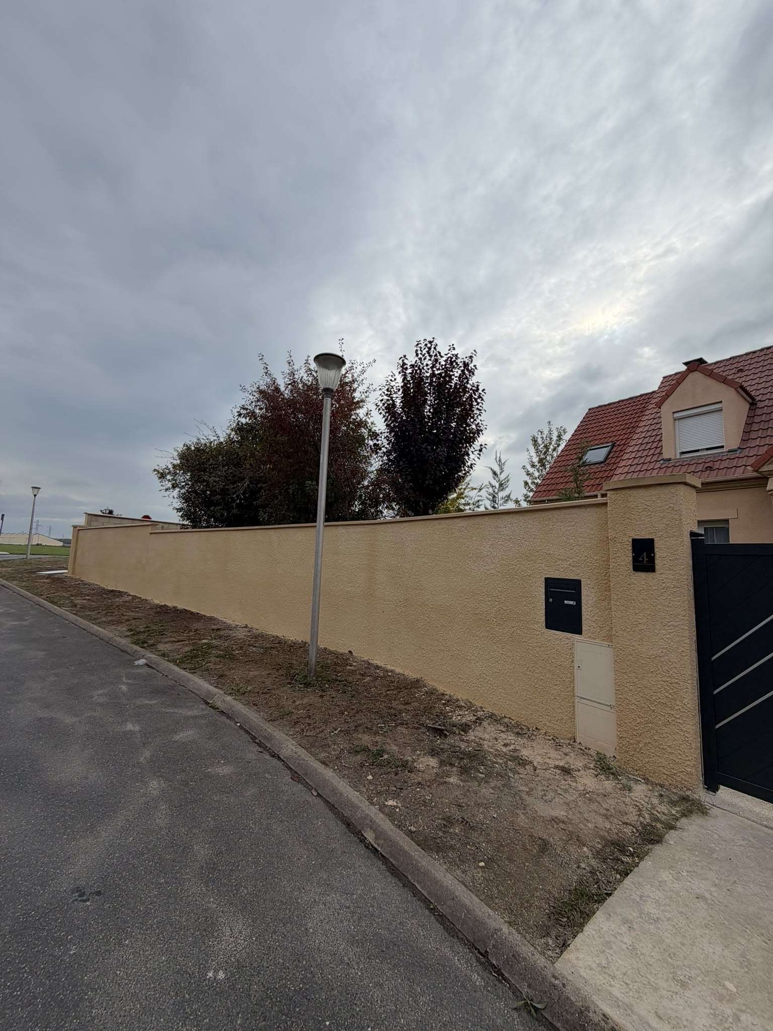 Mur de clôture enduit terminé le long de la rue