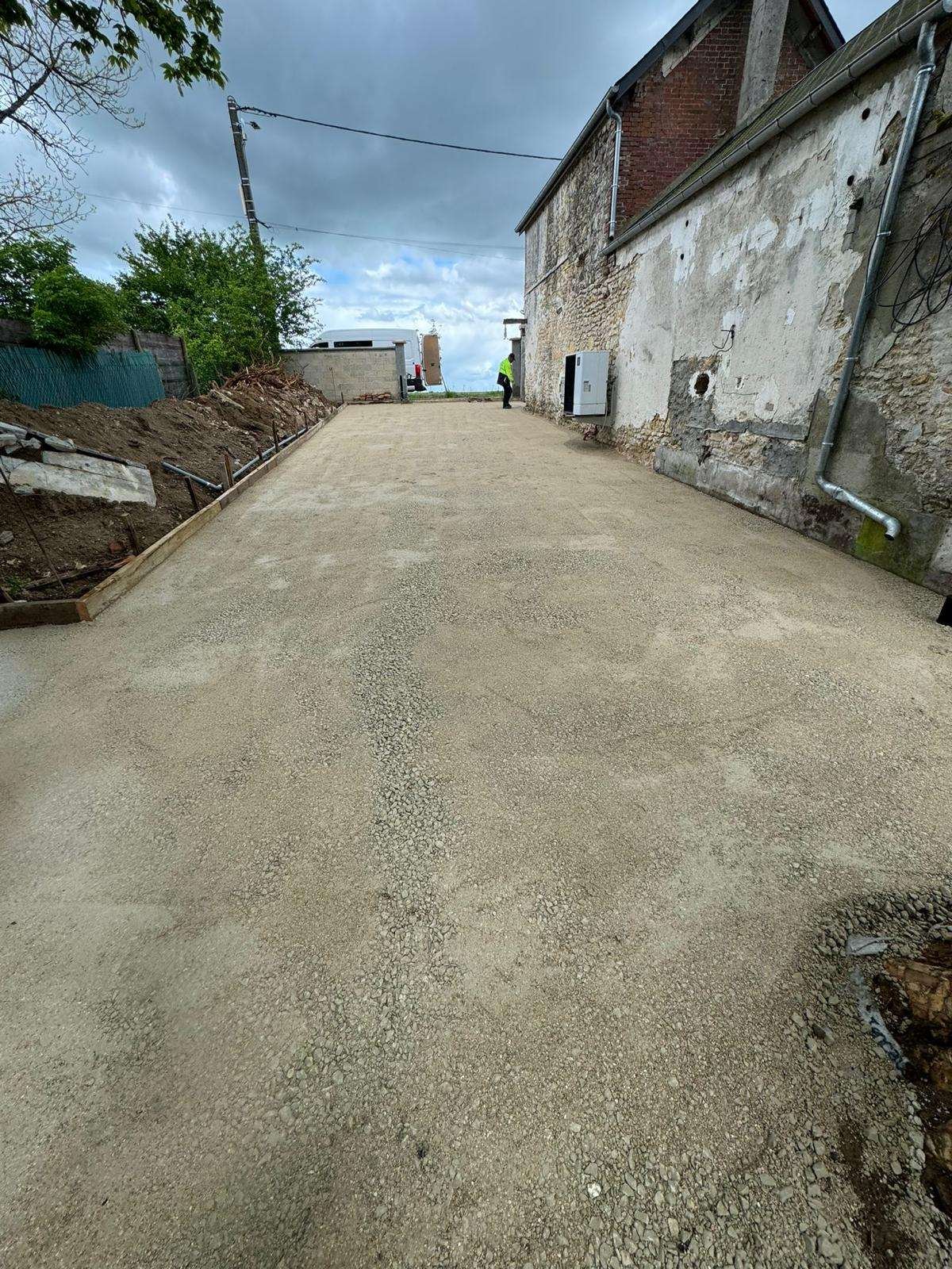 Cour longeant une grange, empierrée et nivelée avant coulage