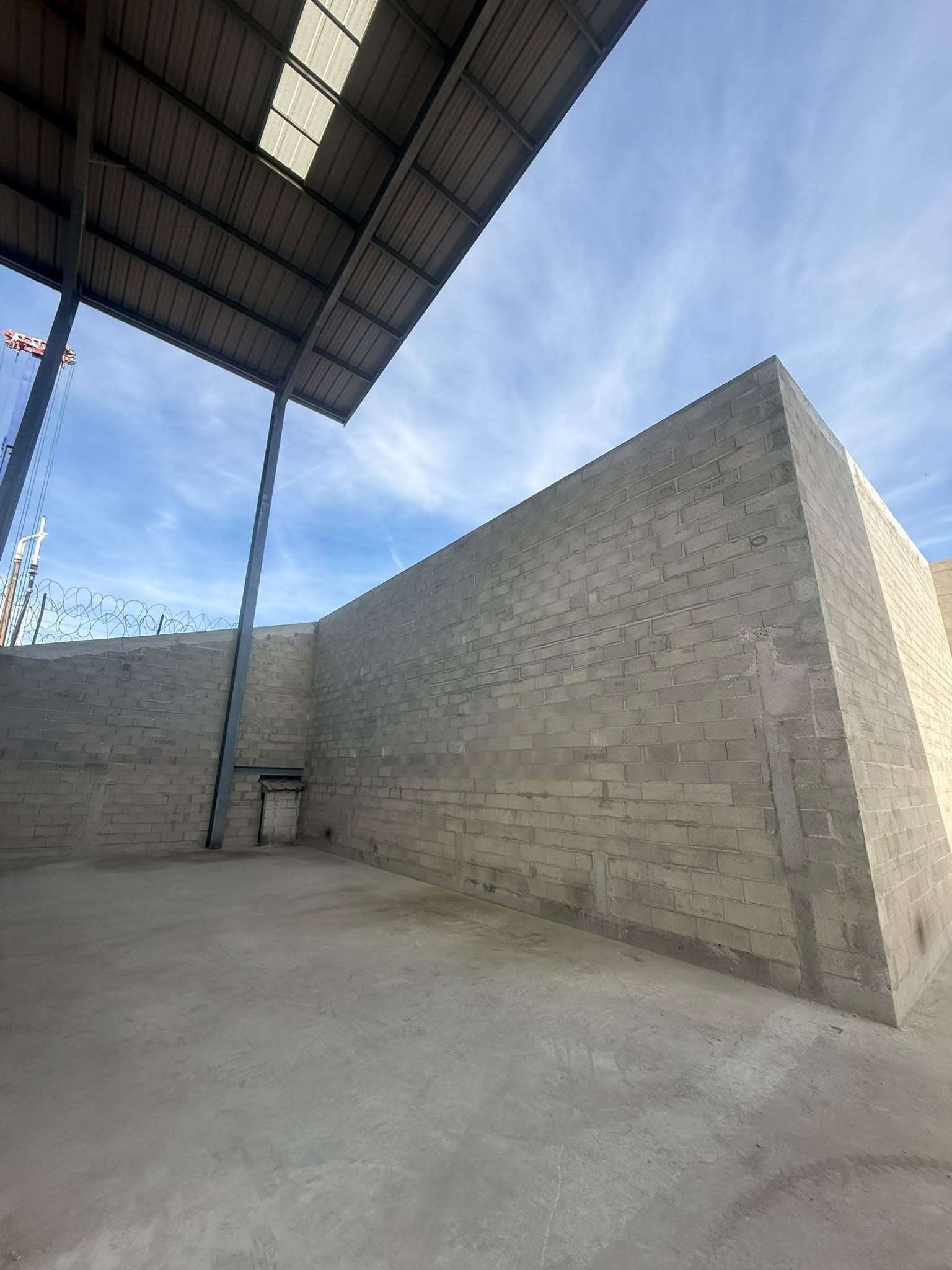Murs en blocs béton sous la charpente métallique d’un hangar